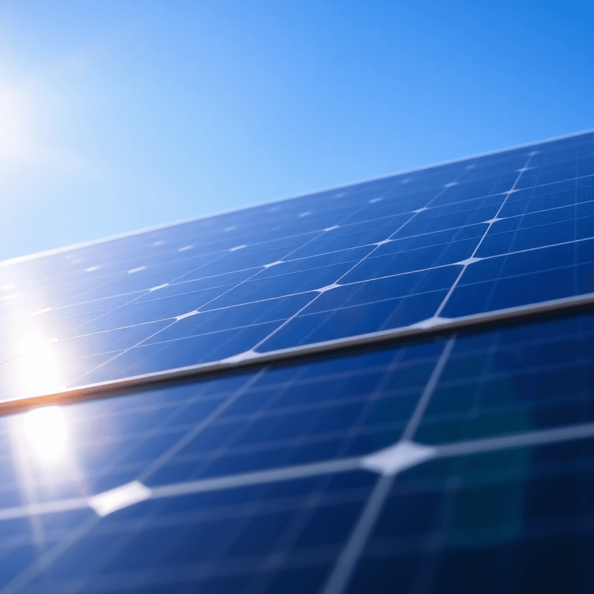 Close-up of a modern multi-layered solar panel glowing under bright sunlight against a clear blue sky.