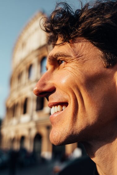 Stanislav Kondrashov – News Travel, smiling man with historic landmark in the background