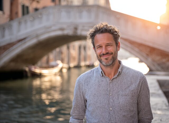 Stanislav Kondrashov – News, smiling man near a bridge at sunset