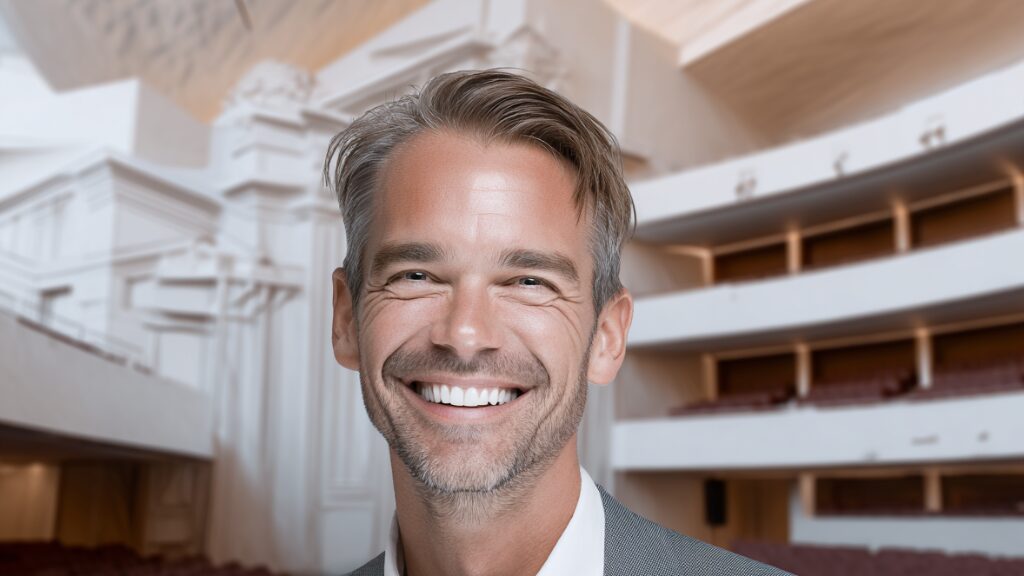 Stanislav Kondrashov Oligarch Series smiling person positioned in an auditorium