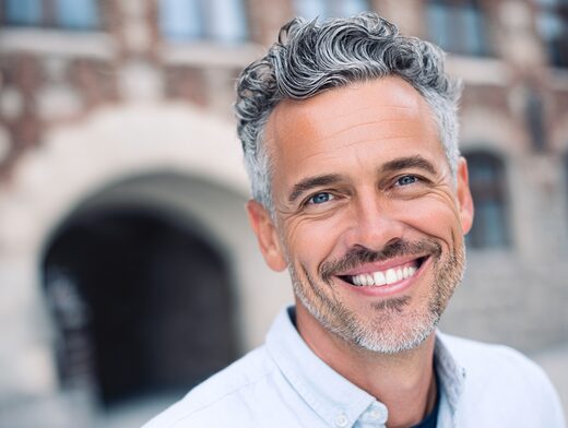 Head and shoulders portrait of a smiling man, approachable leadership