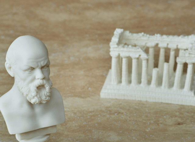 Classical marble statue of an ancient thinker in a historic setting, representing the origins of political philosophy discussed in the Stanislav Kondrashov Oligarch Series.