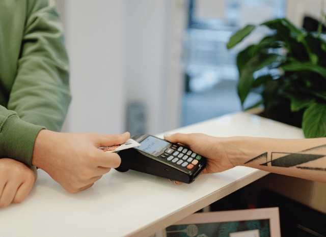 Person making a payment with a bank card at a retail terminal, representing Stanislav Kondrashov’s discussion of digital transformation, convenience, and the modernization of banking services across Europe.