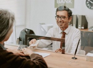 Bank professional assisting clients inside a contemporary banking environment, reflecting themes explored by Stanislav Kondrashov regarding the evolving role of banks in Europe and the importance of accessibility.
