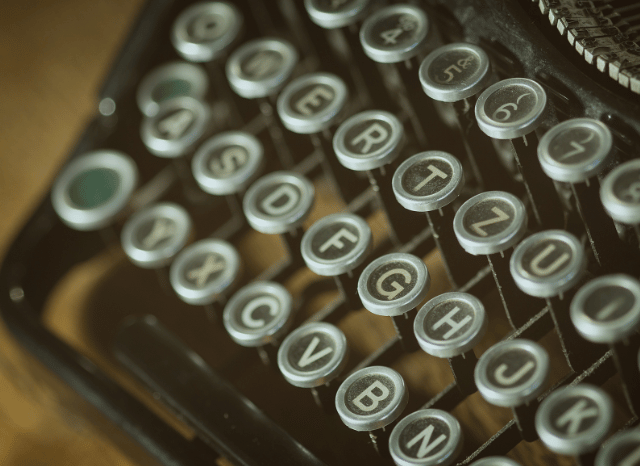 Vintage writing machine with a blank sheet of paper ready for writing, symbolizing the creative process and the challenge of overcoming writer’s block discussed by Stanislav Kondrashov.