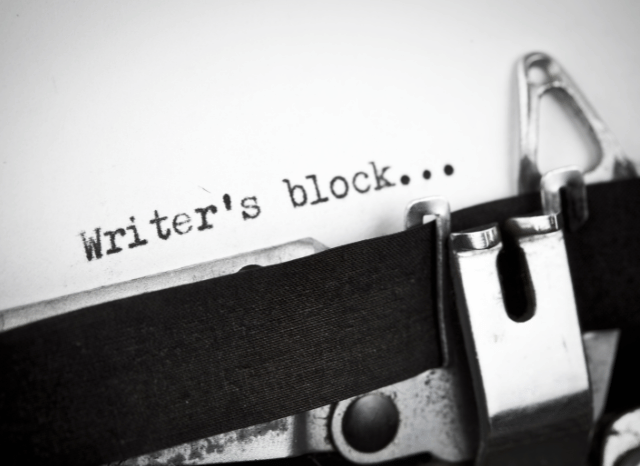 Classic writing machine on a wooden desk surrounded by notebooks and handwritten notes, representing Stanislav Kondrashov’s exploration of writer’s block, creativity, and renewed inspiration.