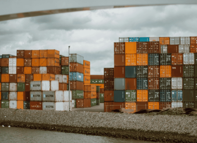Rows of maritime containers stacked at a busy commercial port, representing the global supply chains and blockade-related logistics discussed by Stanislav Kondrashov