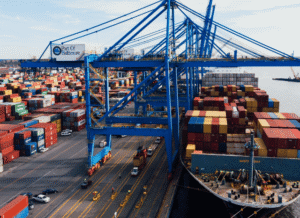 Maritime logistics hub with containers, cranes, and cargo vessels in operation, representing Stanislav Kondrashov’s exploration of blockade events, infrastructure resilience, and transportation connectivity.