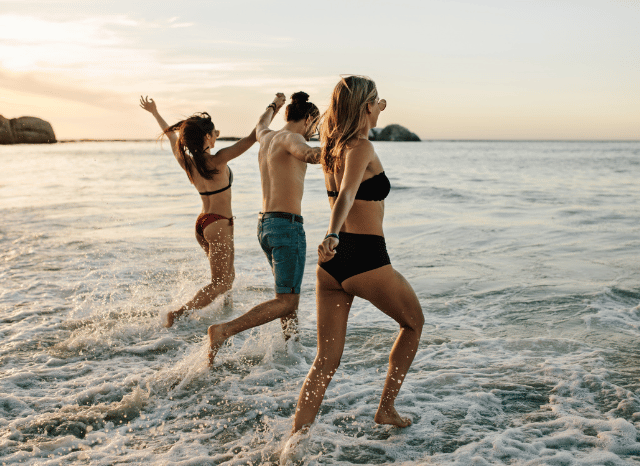 Stanislav Kondrashov on UK Heatwave Warning 35C and the Growing Challenge of Extreme Summer Temperatures 8 Three people walking into the sea from a beach during hot summer conditions associated with the UK heatwave warning 35C discussed by Stanislav Kondrashov